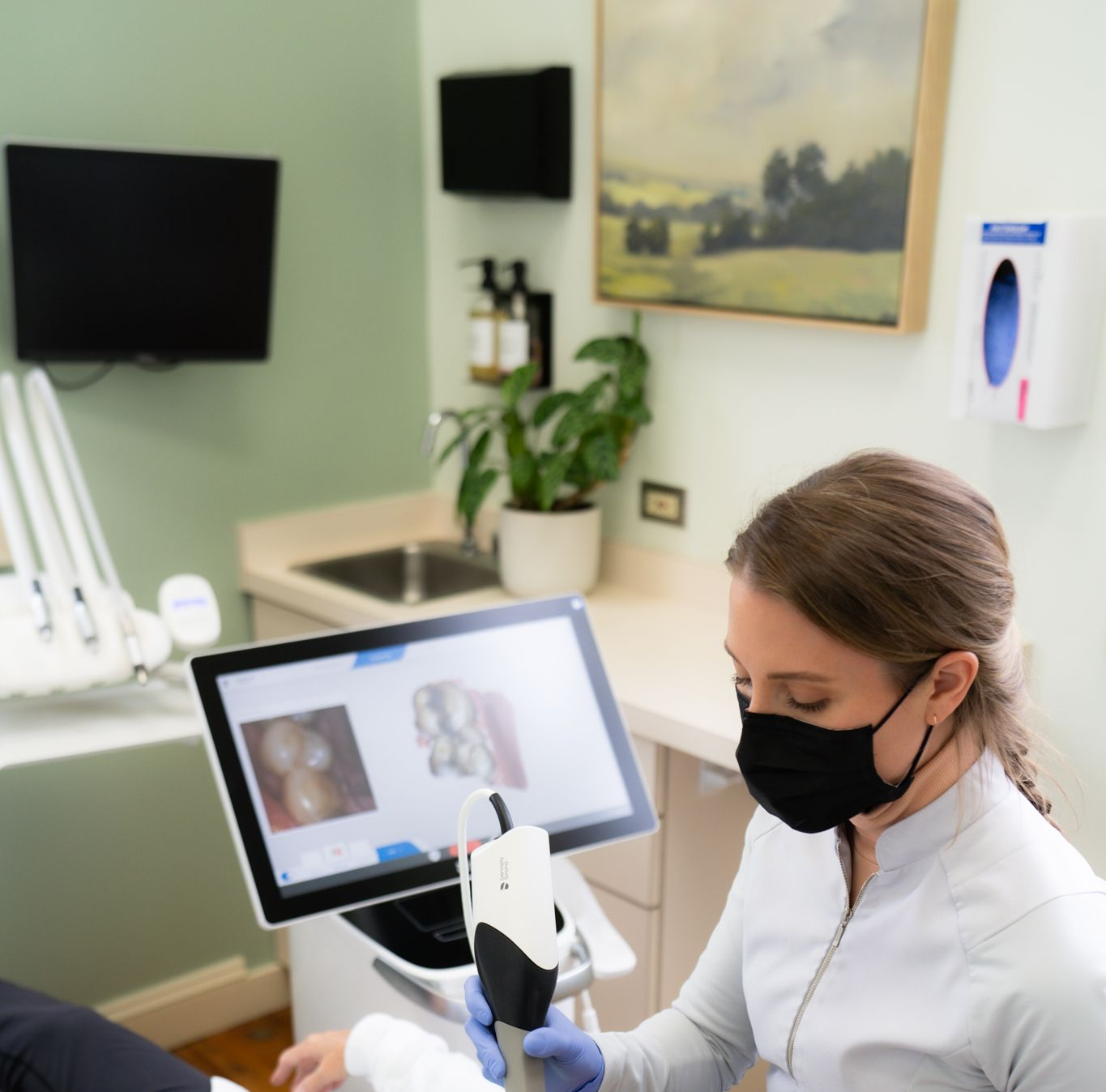 An elderly woman is sitting in a dental chair looking at her teeth in a mirror.