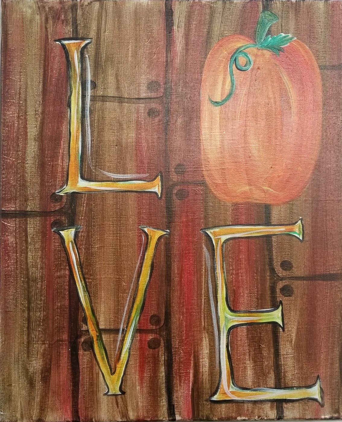 Wooden sign with gold “L” and “VE” letters beside an orange pumpkin on a rustic brown background.