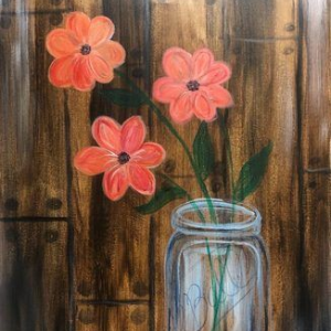 Three coral flowers in a glass jar against a rustic wood plank background