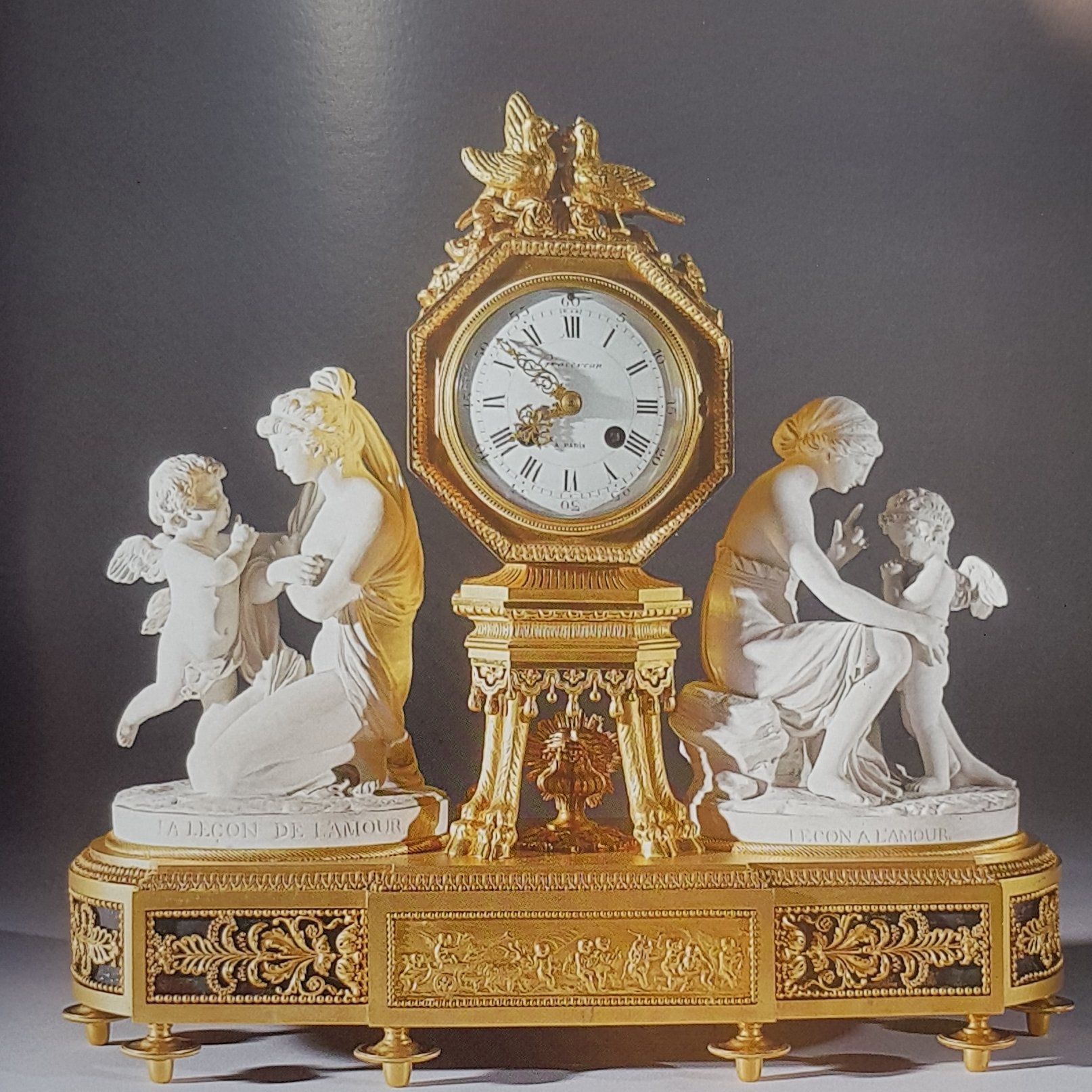 Pendola da tavolo in bronzo dorato con base ovoidale sostenuta da otto piedini a trottola