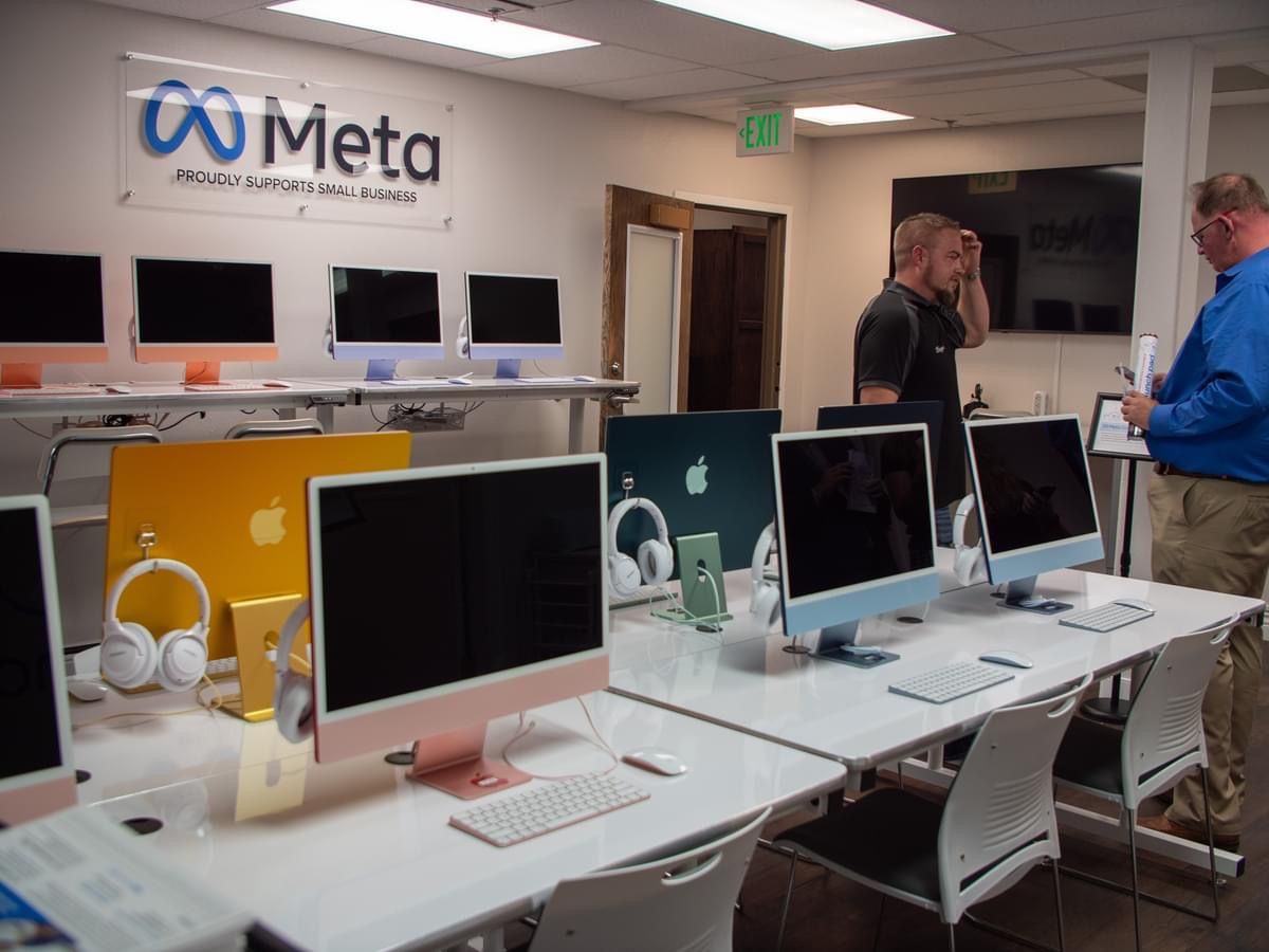 A group of people standing in front of a sign that says meta
