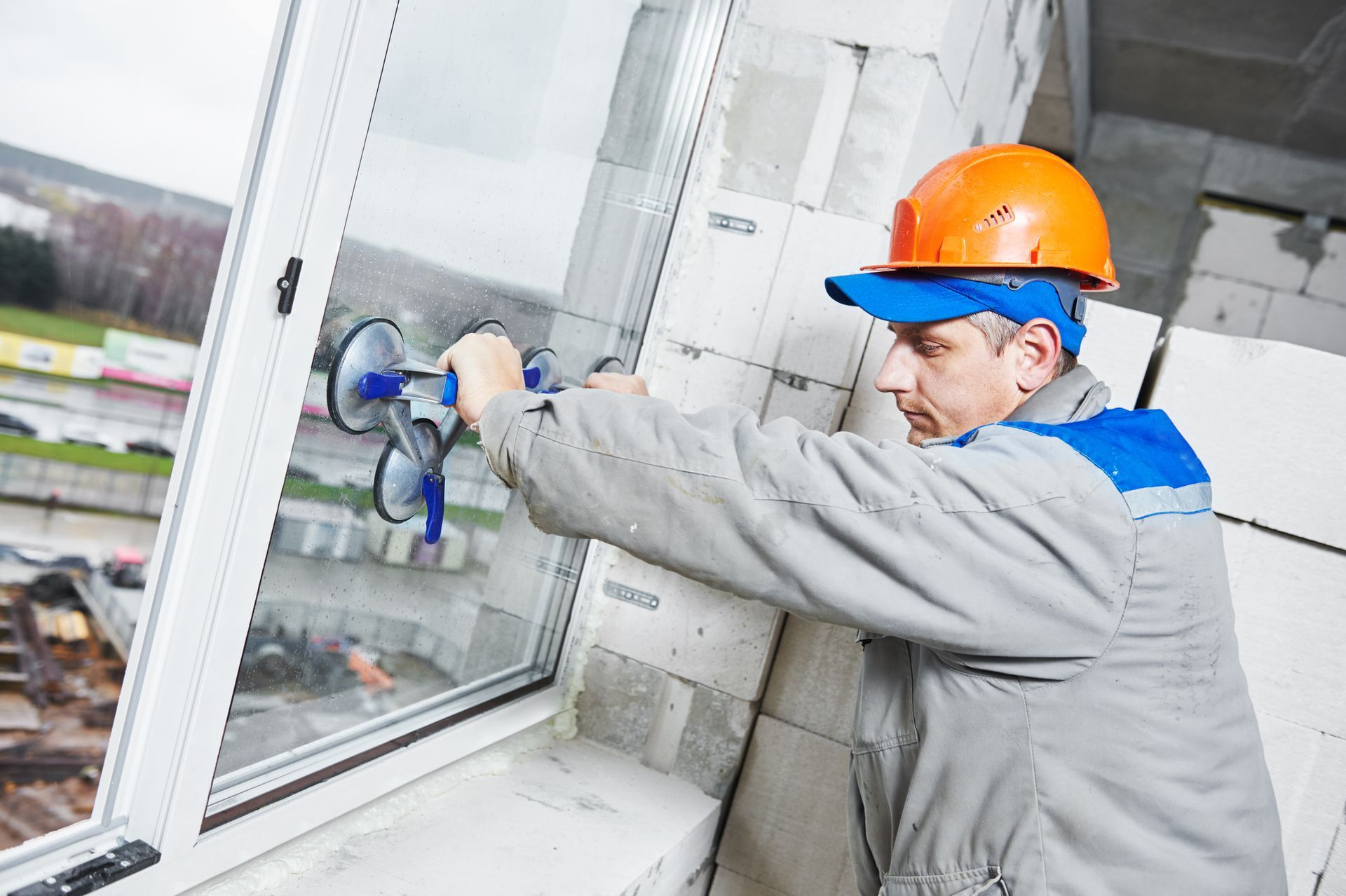 Worker from Ken Caryl Glass, Inc., carrying a new window for replacement in Colorado Springs, CO