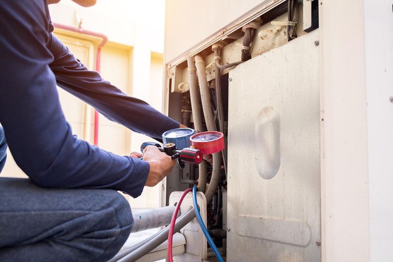 Worker using a drill on exposed wiring inside a wall cavity