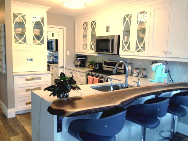 Breakfast bar with a live edge slab installed in newly renovated kitchen.