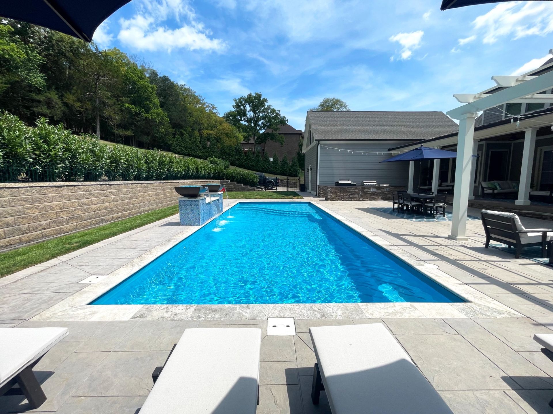 Elegant pool design with water bowls and pergola seating area in Eagleville by Majestic Swim