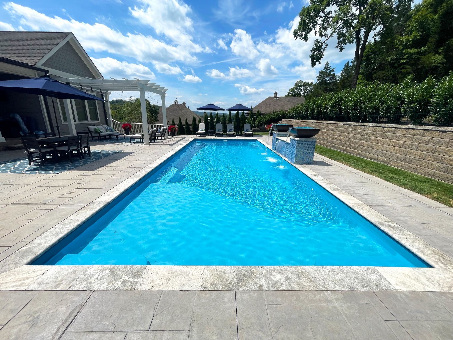 Sunlit view of luxury inground pool with custom stonework in Eagleville by Majestic Swim