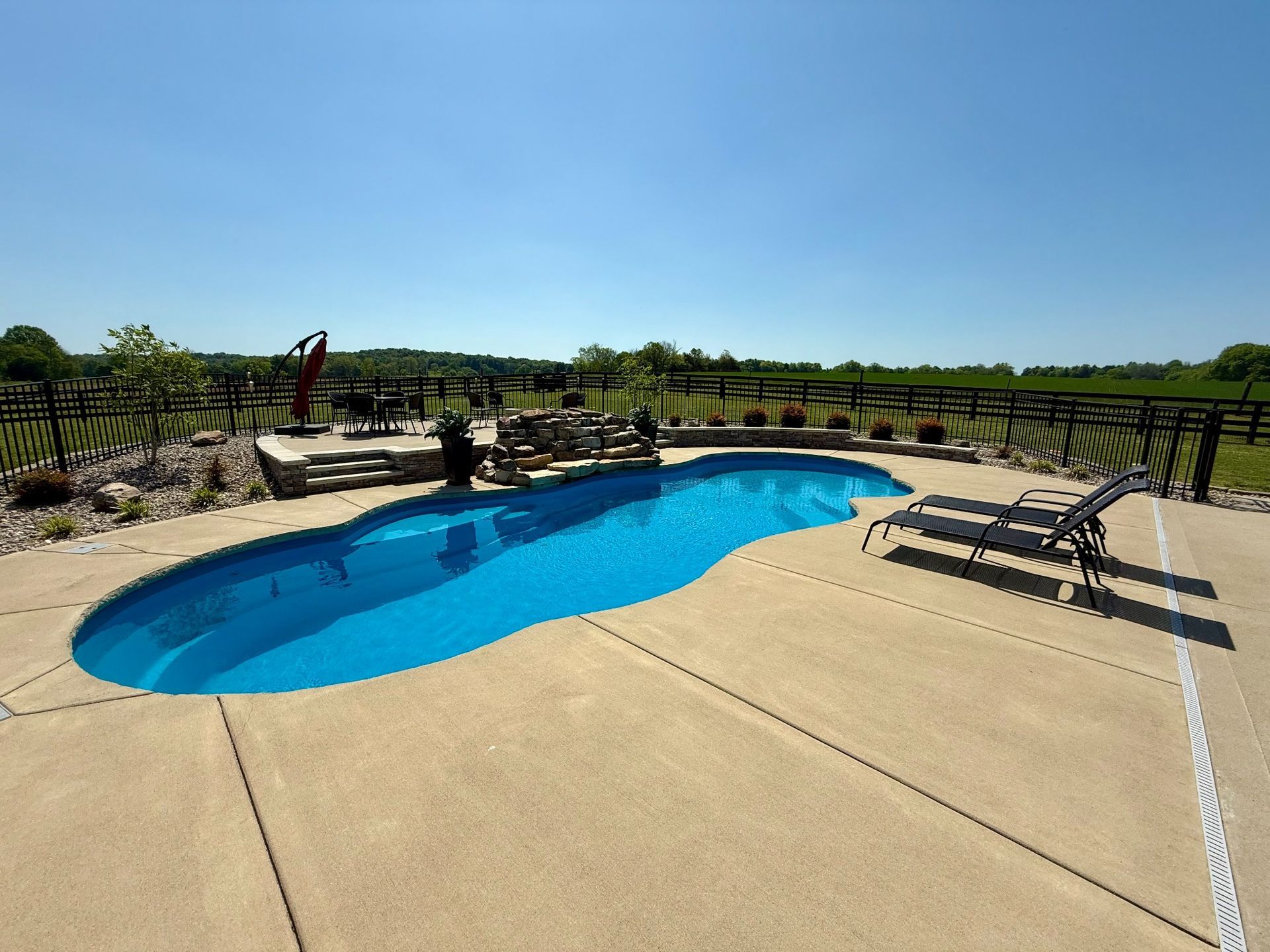 Overview of a 16x40 inground pool in Lascassas with surrounding lounge area and open field views
