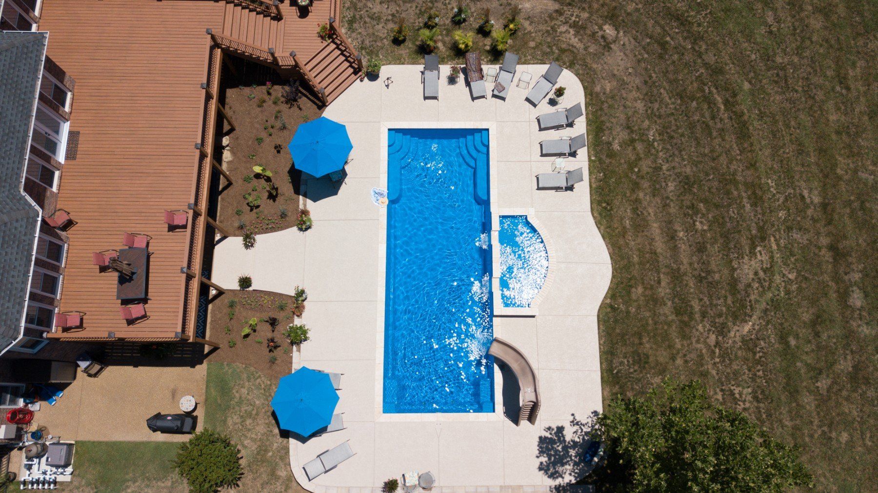 An aerial view of a large swimming pool surrounded by chairs and umbrellas.