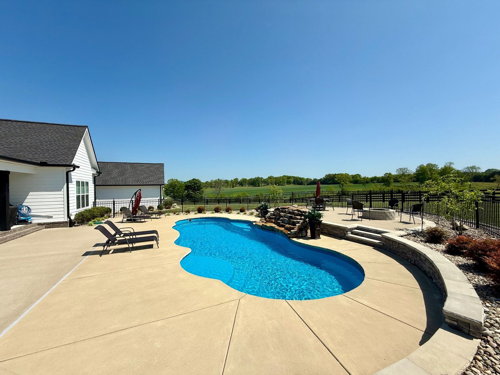 Curved concrete pool deck and patio space around a 16x40 pool in Lascassas