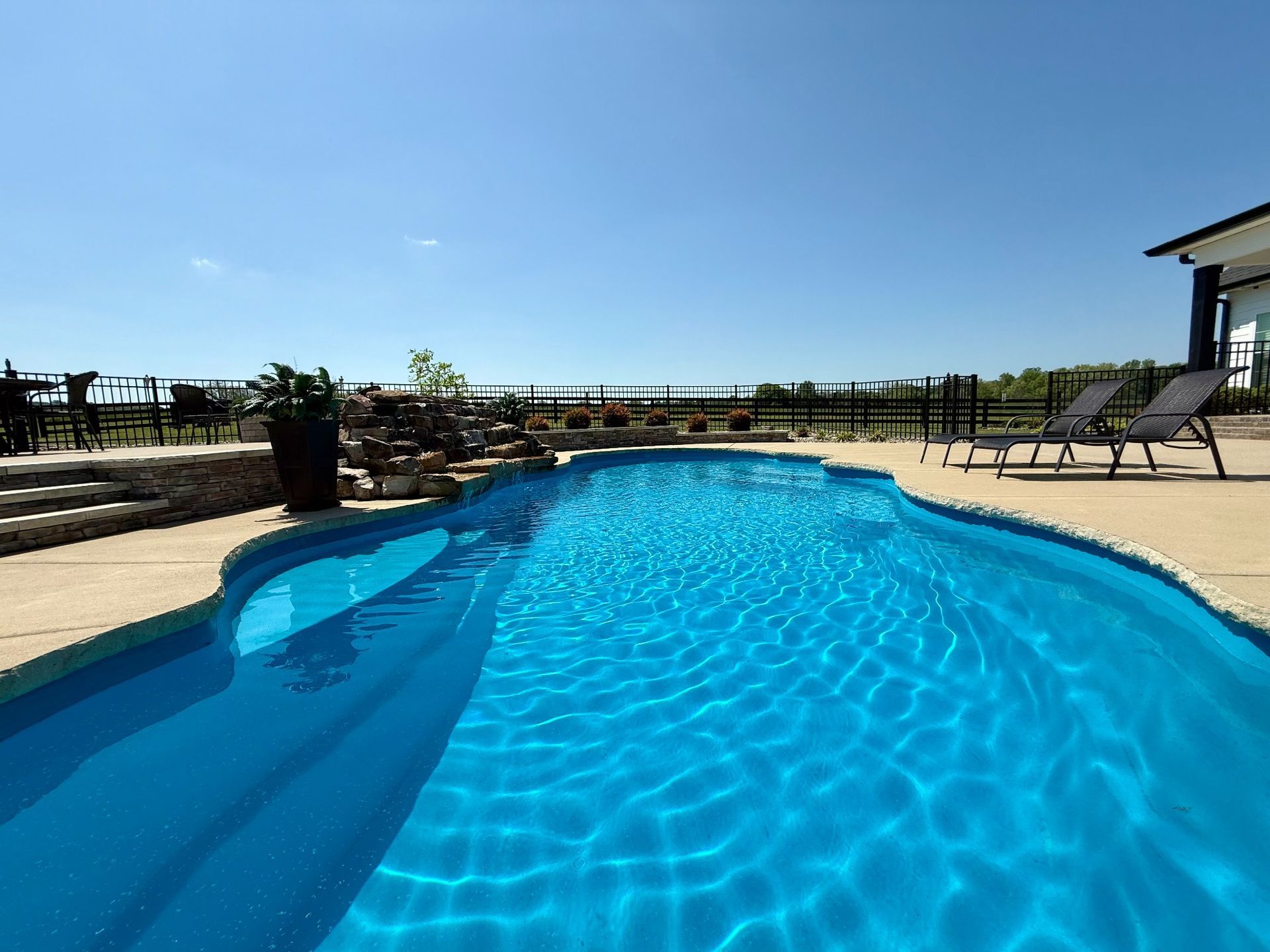 Side view of the 16x40 pool showing curved design and stone waterfall