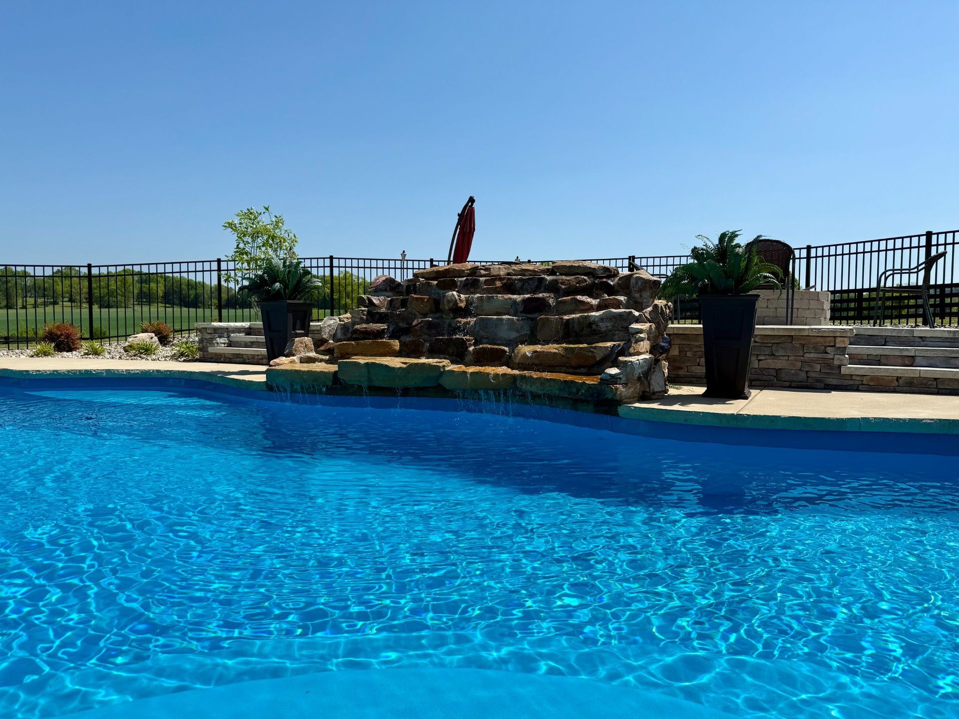 Close-up of natural stone waterfall feature flowing into pool in Lascassas, TN