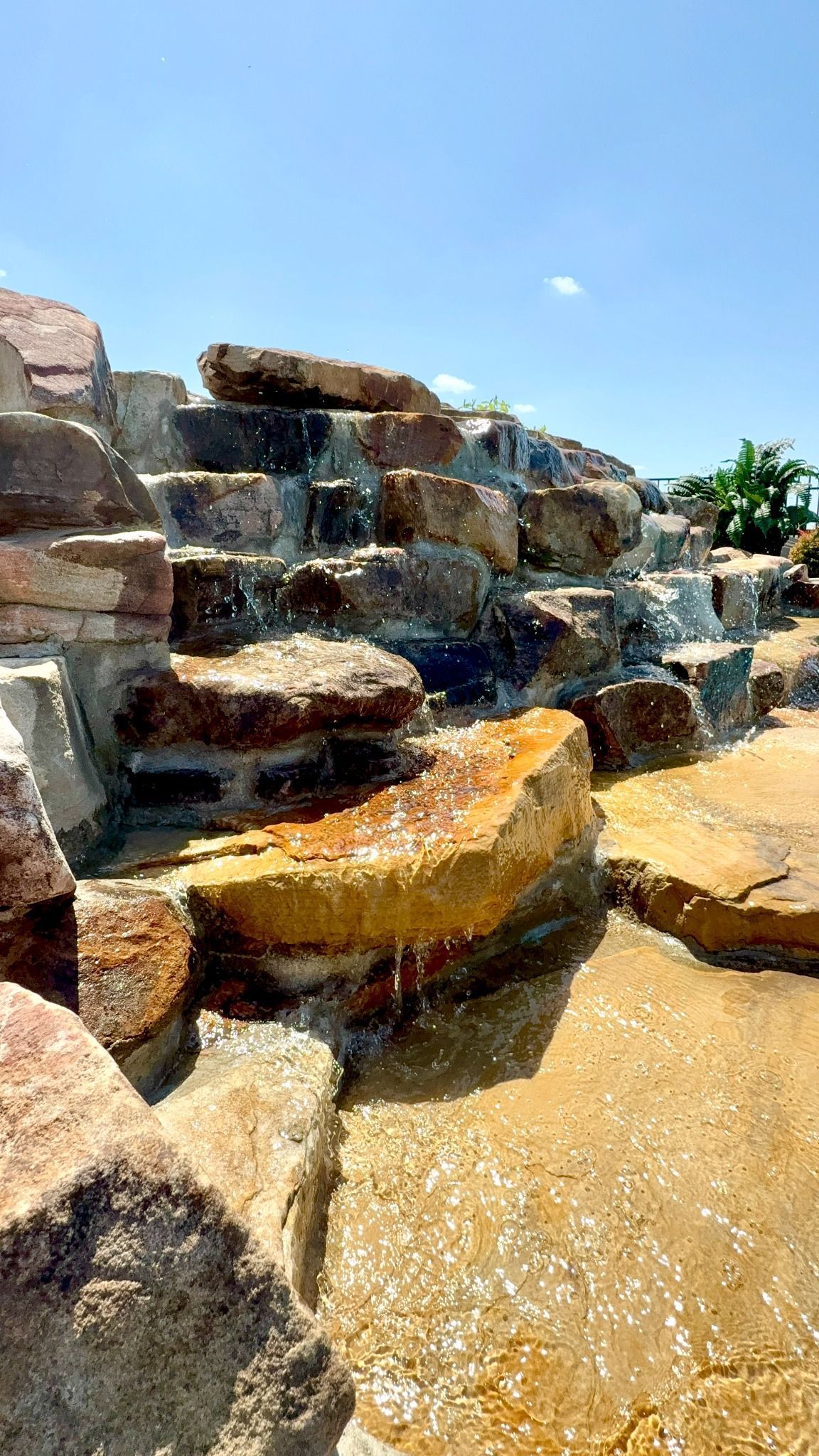 Close-up of natural stone waterfall feature flowing into pool in Lascassas, TN