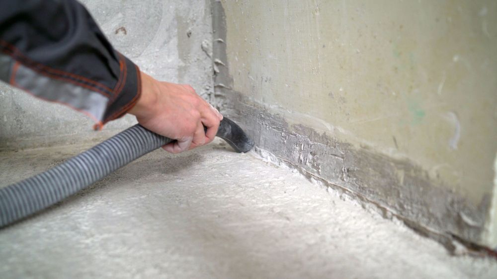 Hand Using a Vacuum Nozzle to Clean Dust Along a Wall Floor Seam — Restore All Qld in Toowoomba, QLD