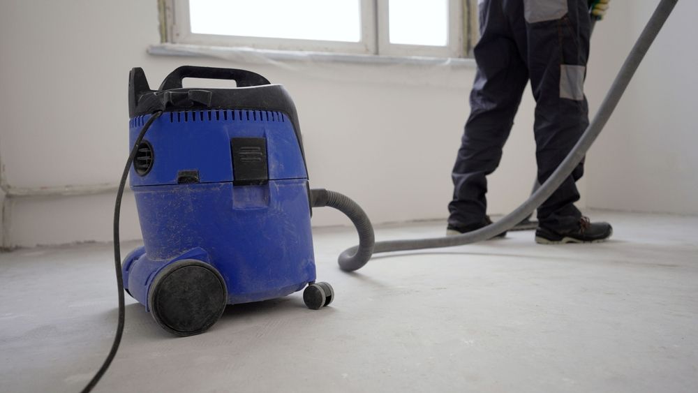 Blue Wet or Dry Vacuum on A Floor Being Used with A Hose to Clean Dusty Floor — Restore All Qld in South Burnett, QLD