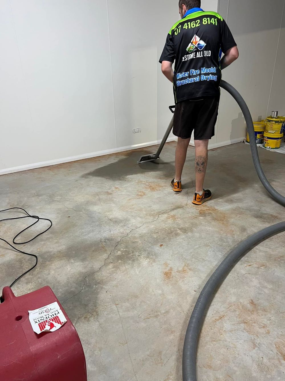 A Man is Cleaning a Concrete Floor — Restore All Qld in Fraser Coast, QLD