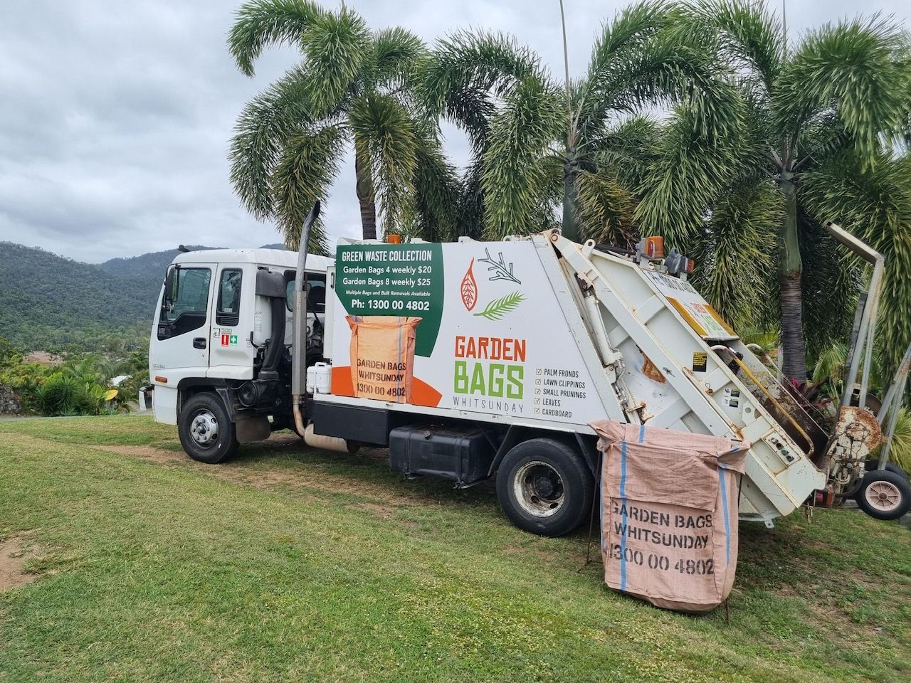 A Rubbish Truck Is Parked In A Grassy Field — Garden Bag in Kelsey Creek, QLD