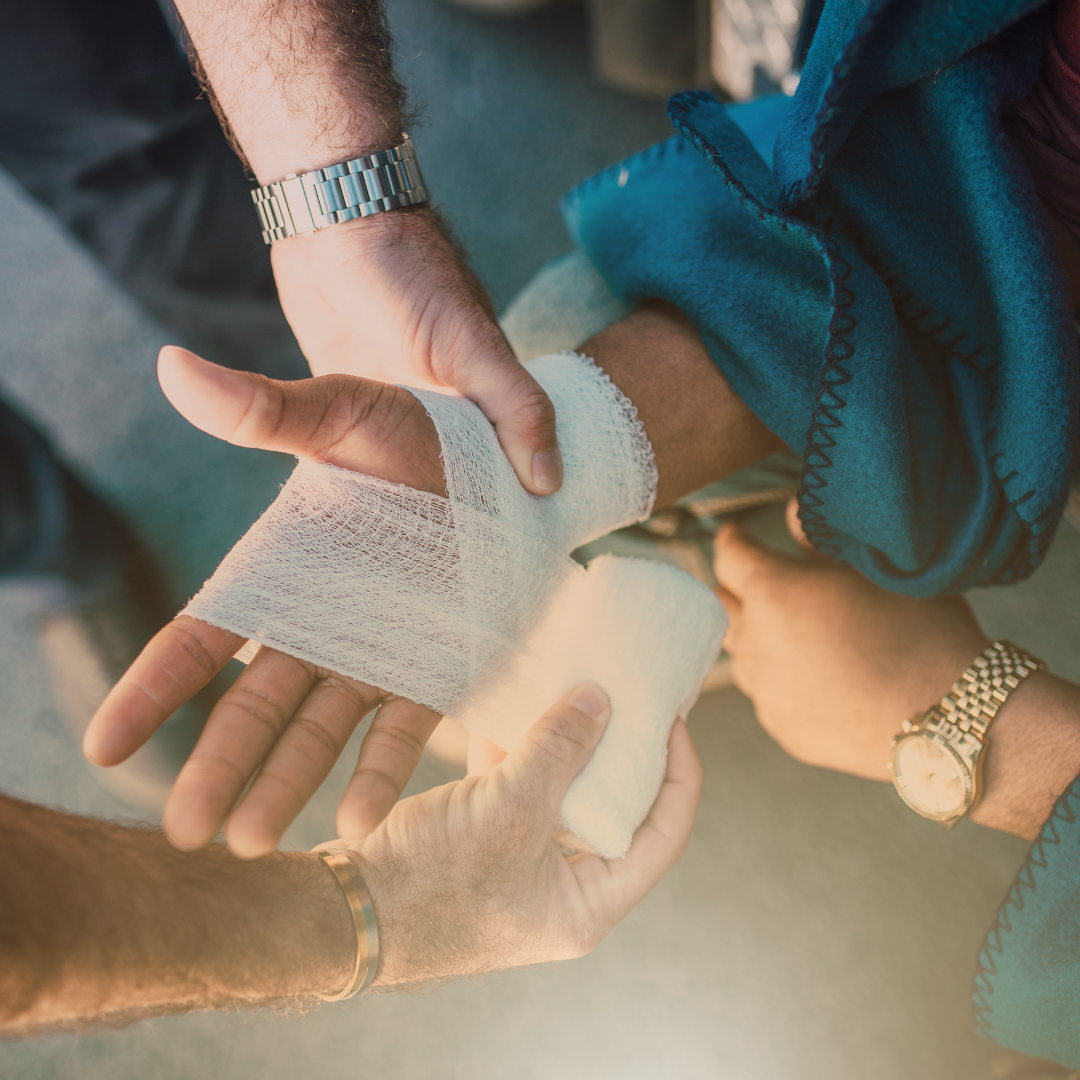 Man wrapping bandage on another persons hands