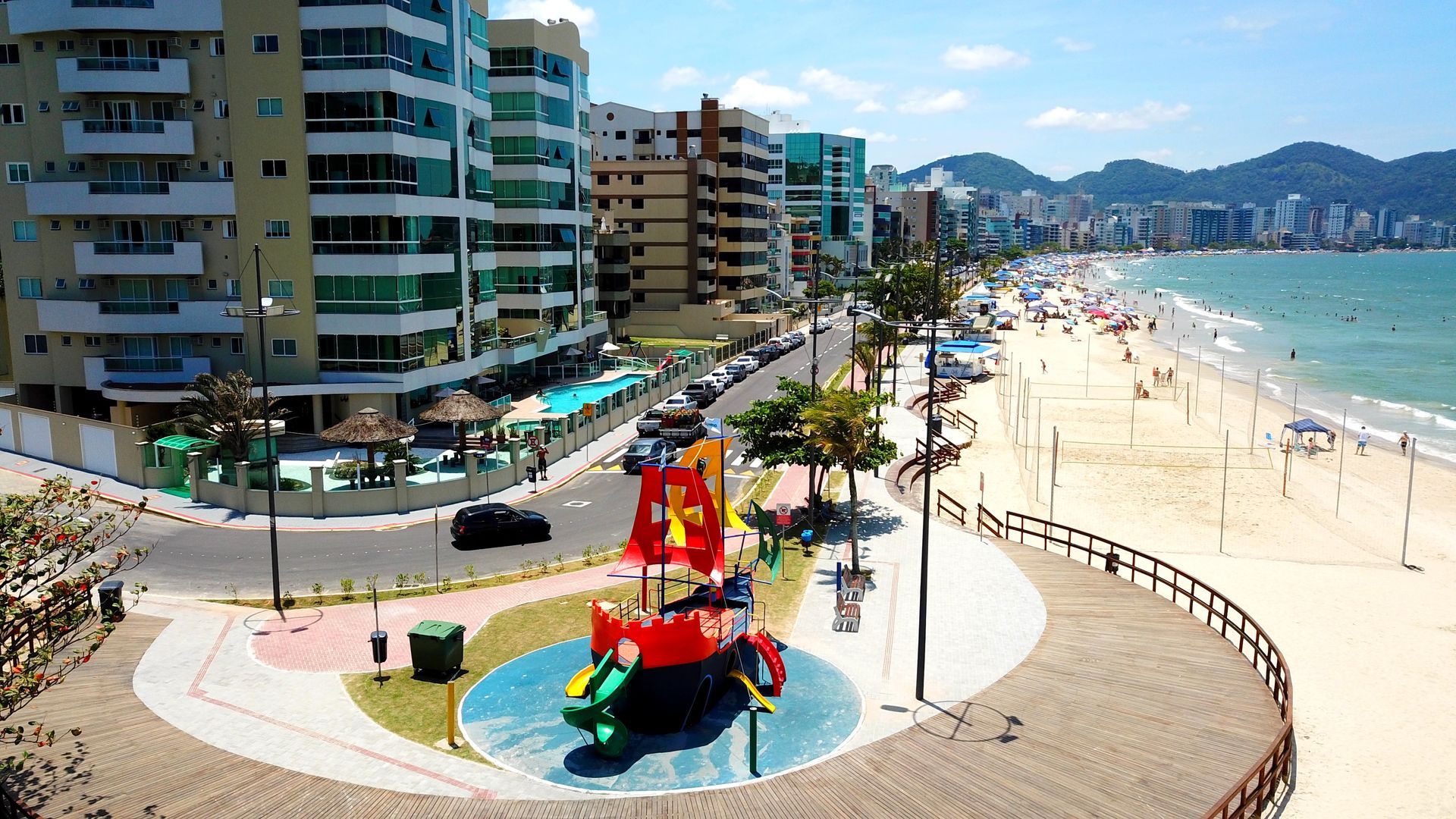Vista aérea de uma praia com playground em primeiro plano