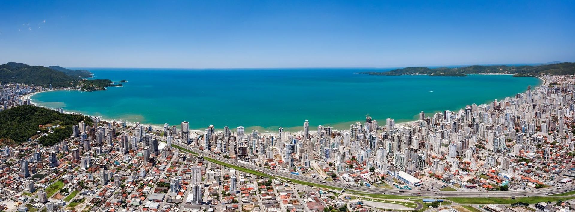 Uma vista aérea de uma cidade com um grande corpo de água ao fundo.