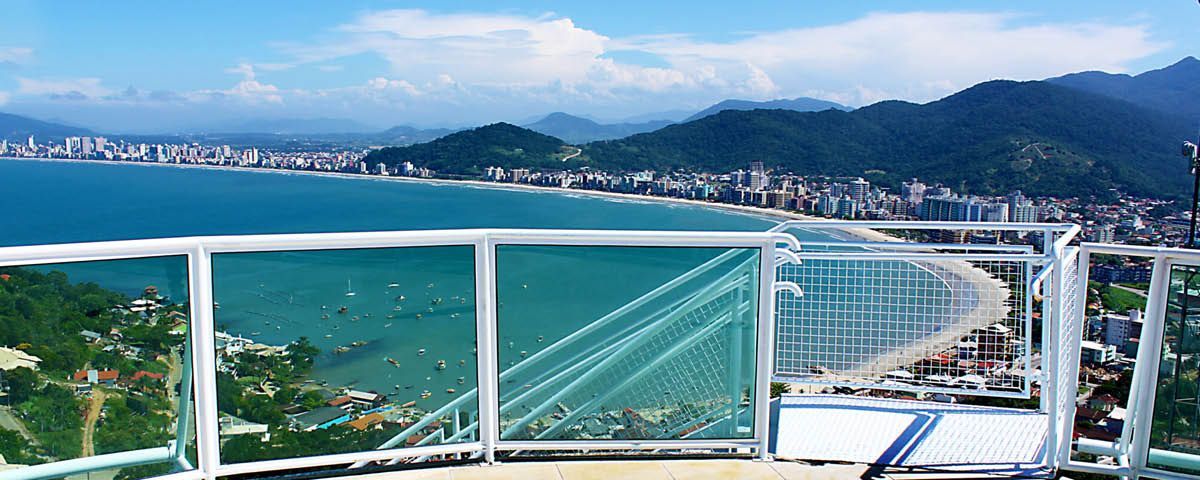 Uma varanda com vista para o mar e para as montanhas.