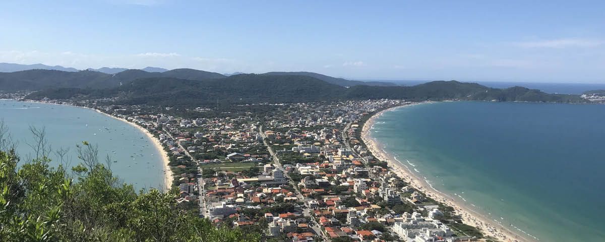 Uma vista aérea de uma cidade cercada por água e montanhas.