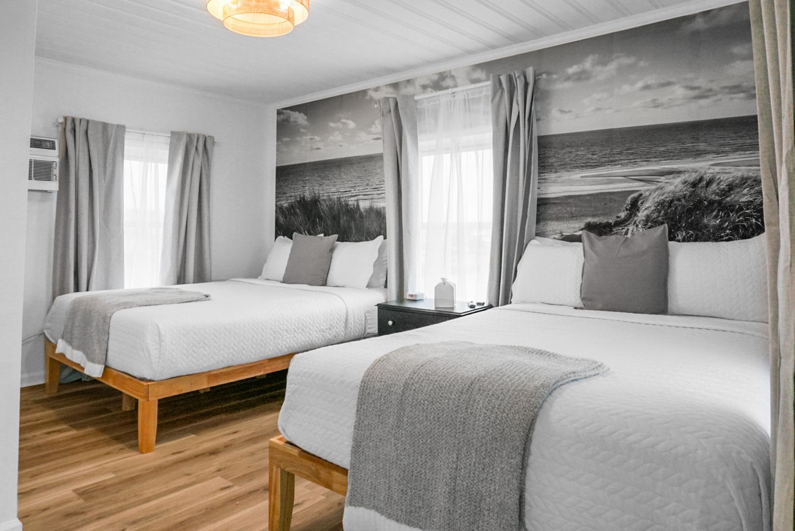 A bedroom with a bed , desk , lamp and mirror.