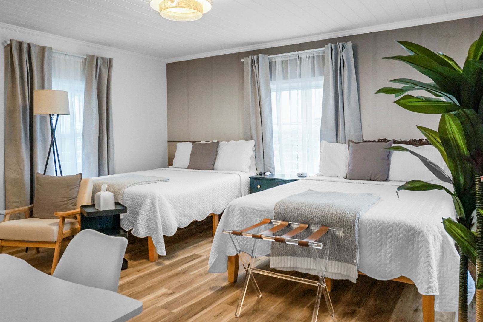 There are two beds and a chair in the room.
