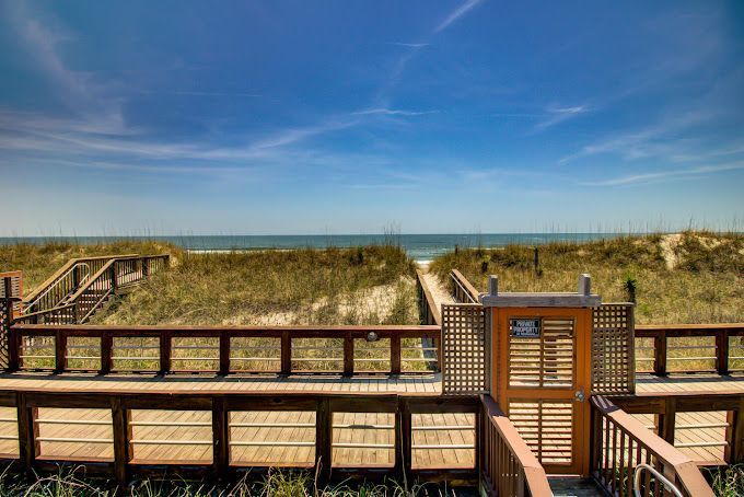 There is a wooden walkway leading to the beach.