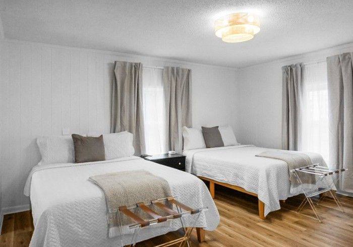 There are two beds and a chair in the room.