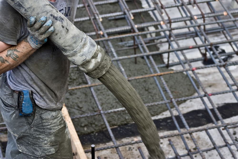 Construction Worker Pouring Concrete Onto Rebar Framework — Wieland Concreting in Rockhampton, QLD