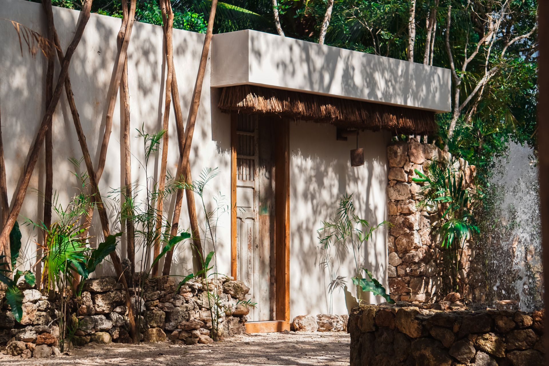 Pequeño edificio moderno de piedra y madera, enclavado entre los árboles de un bosque soleado.