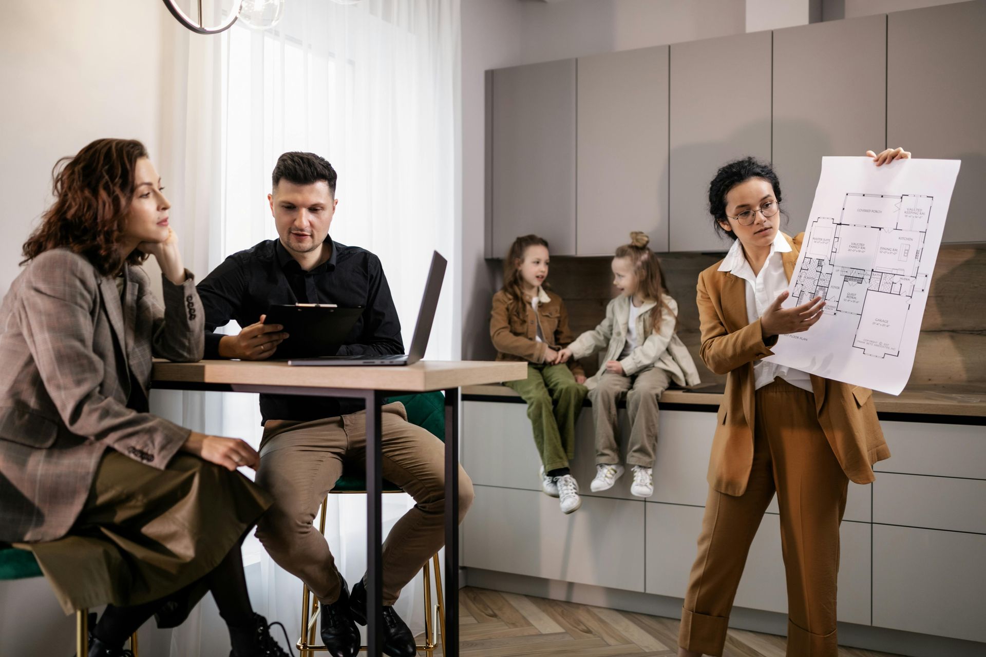 Team meeting in a modern office, with one person presenting a chart beside seated colleagues.