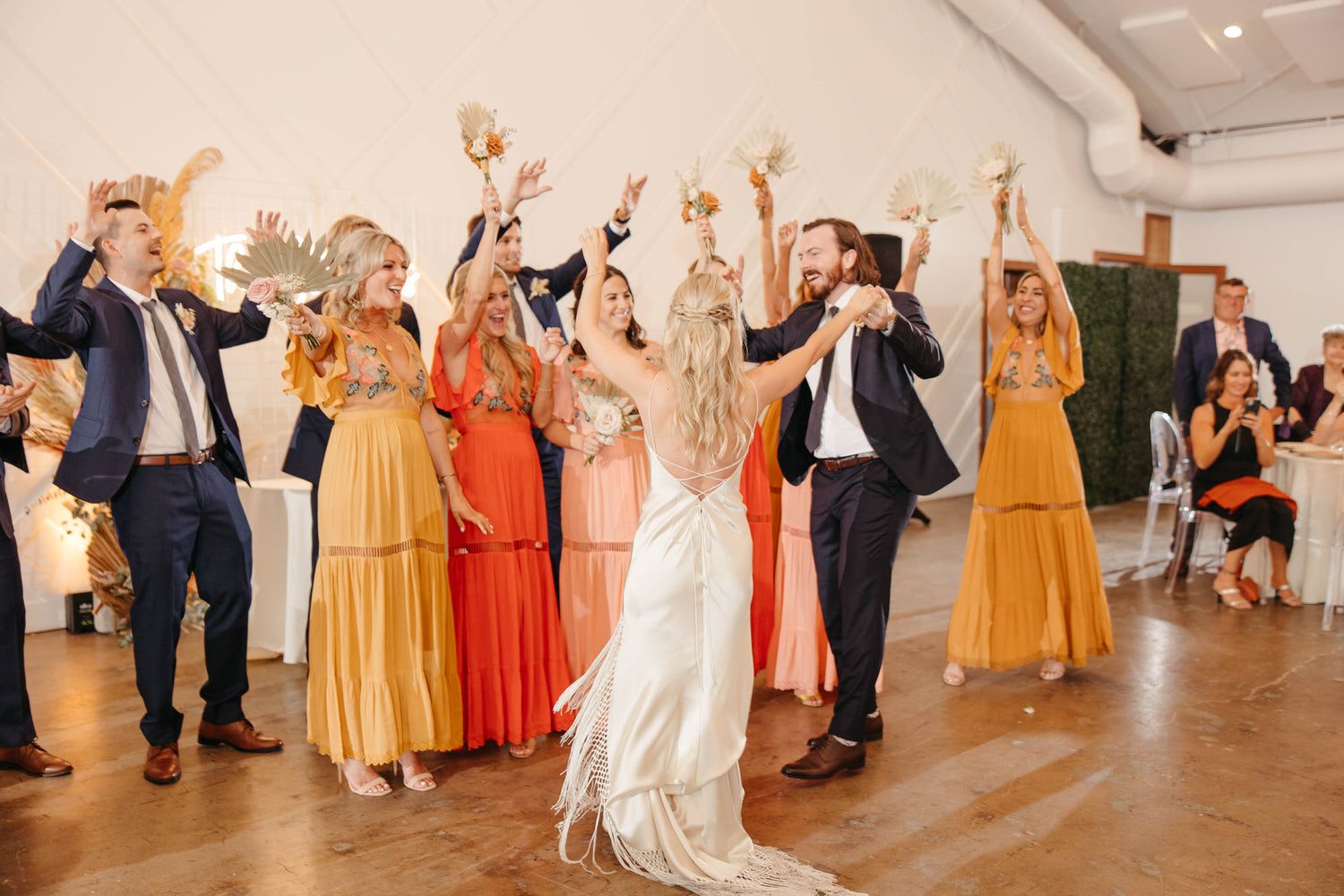 A bride and groom are dancing with their wedding party at their wedding reception.
