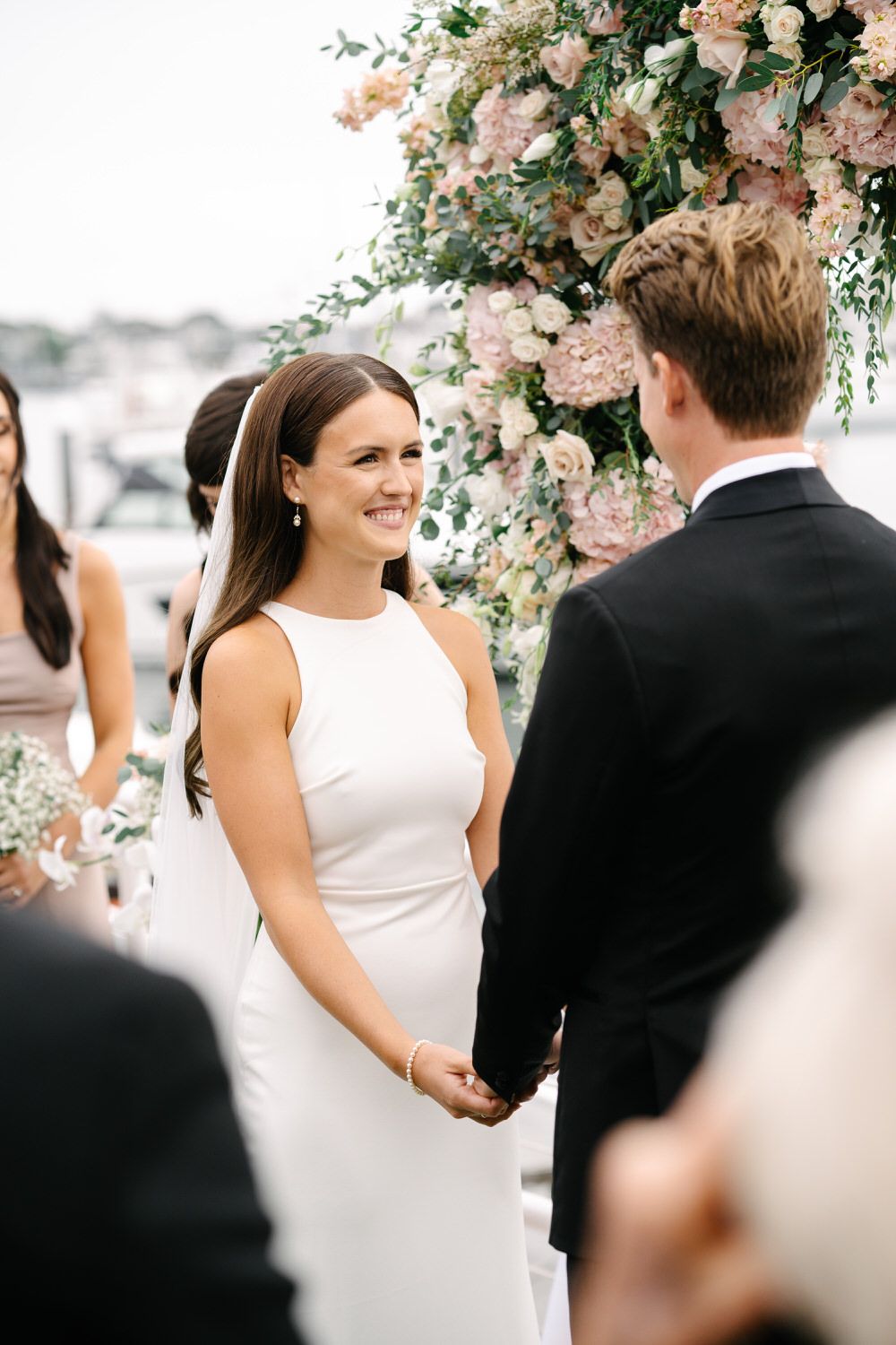 Orange county hair and makeup artist. A bride and groom are holding hands during their wedding ceremony.