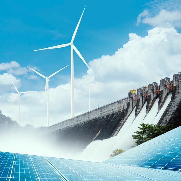 Wind turbines above a hydroelectric dam with blue solar panels in the foreground