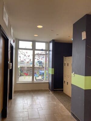 A hallway with a lot of windows and lockers in a building.