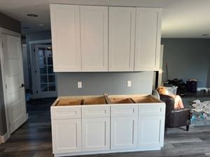 A kitchen with new white cabinets being installed