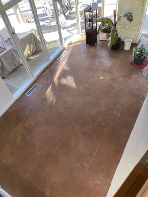 An aerial view of a living room with a concrete floor and lots of windows.