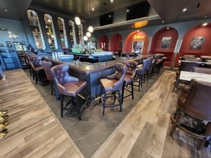 A restaurant with a long bar and lots of chairs.