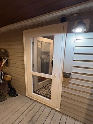 A white door with a mirror on the side of a house.