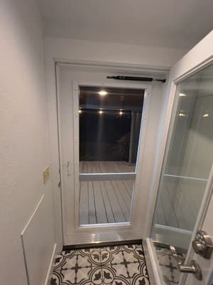 A bathroom with a glass door leading to a deck.