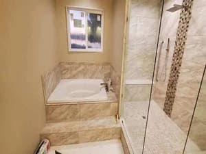 A bathroom with a tub and a walk in shower.