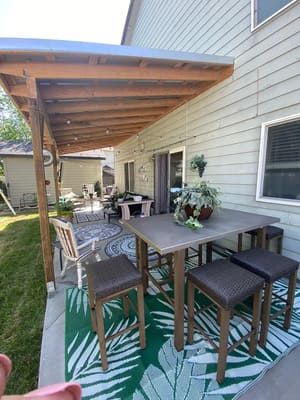 A patio with a table and chairs under a canopy.