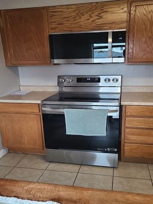 A kitchen with stainless steel appliances and wooden cabinets.