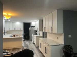 A kitchen with white cabinets and granite counter tops is being remodeled.