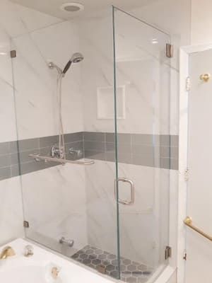 A bathroom with a glass shower door and a bathtub.