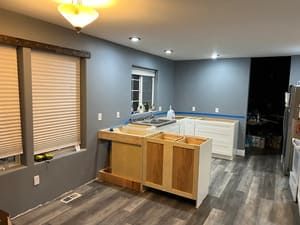 A kitchen with a sink , cabinets , and a window.