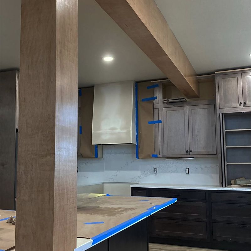 A kitchen under construction with a wooden pillar in the middle