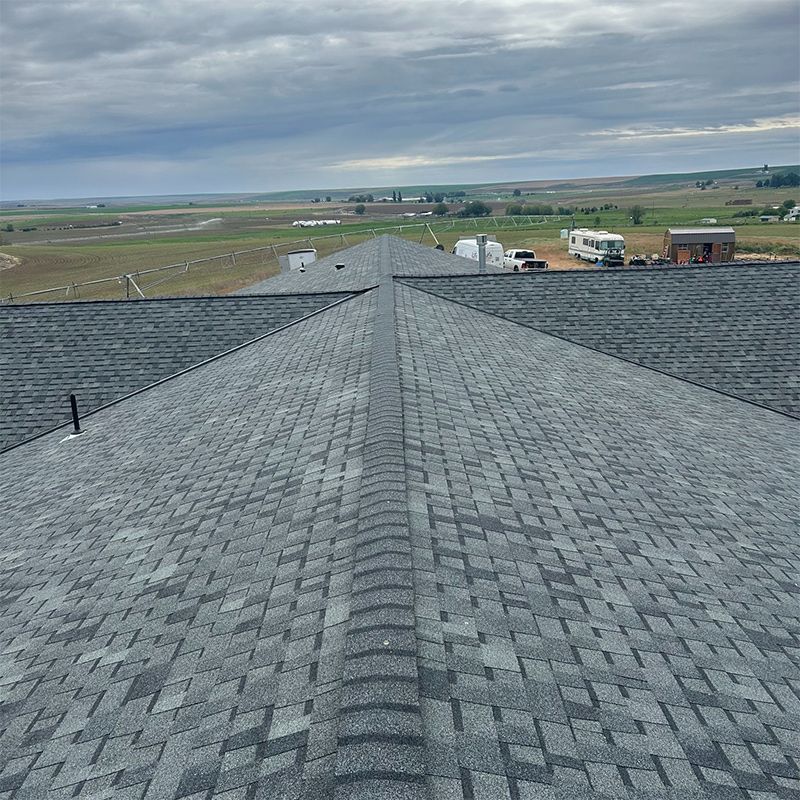 A roof with a lot of shingles on it and a view of a field.