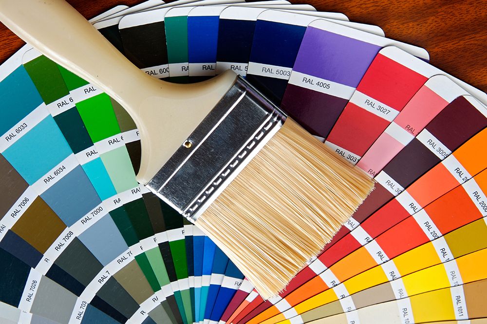 A paint brush is sitting on top of a color wheel